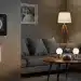 Smart living room with home automation devices including thermostat, smart lights, and voice assistant